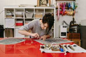 Julie Wall carves a linoleum block by hand in her studio. 